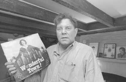 David Ryan holding a Wonderful Town record inside the basement apartment at 14 Gay Street; photograph published by The Villager