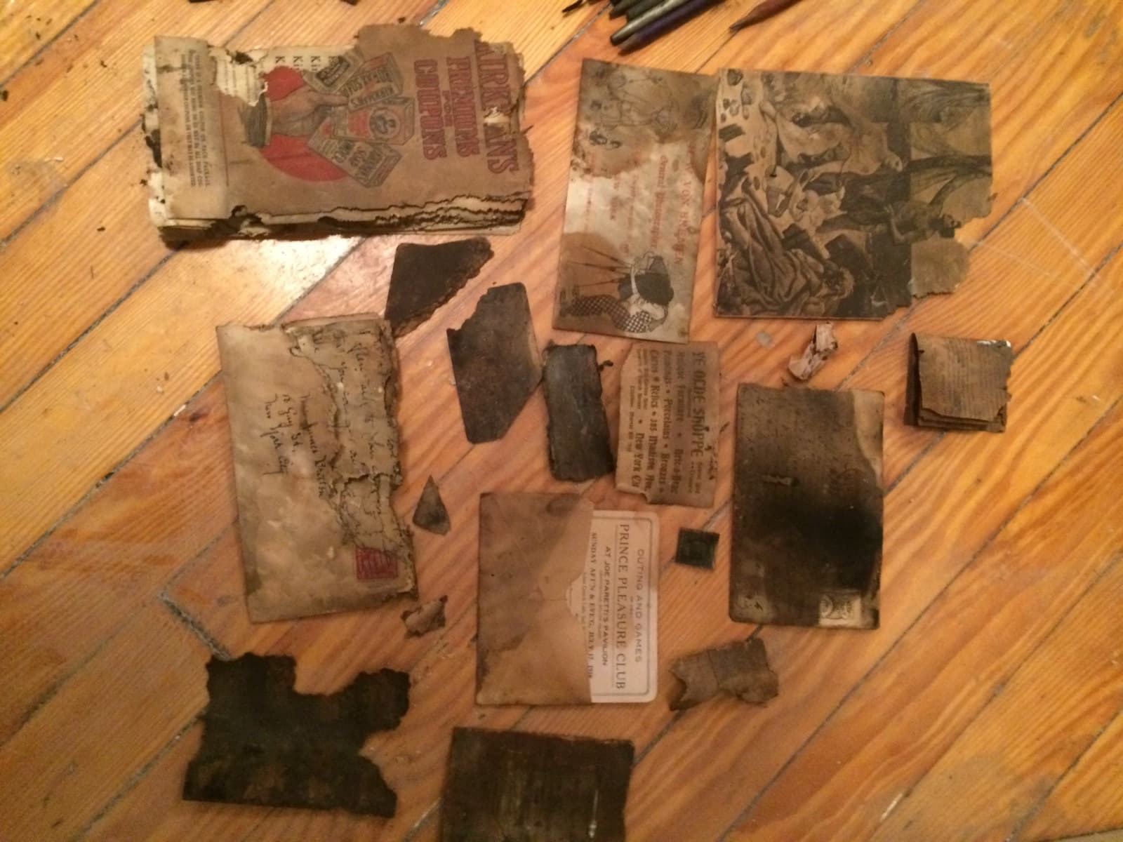 Paper ephemera found inside the wall at 18 Gay Street, including a Prince Pleasure Club outing ticket and a Ye Olde Shoppe business card, November 7, 2014