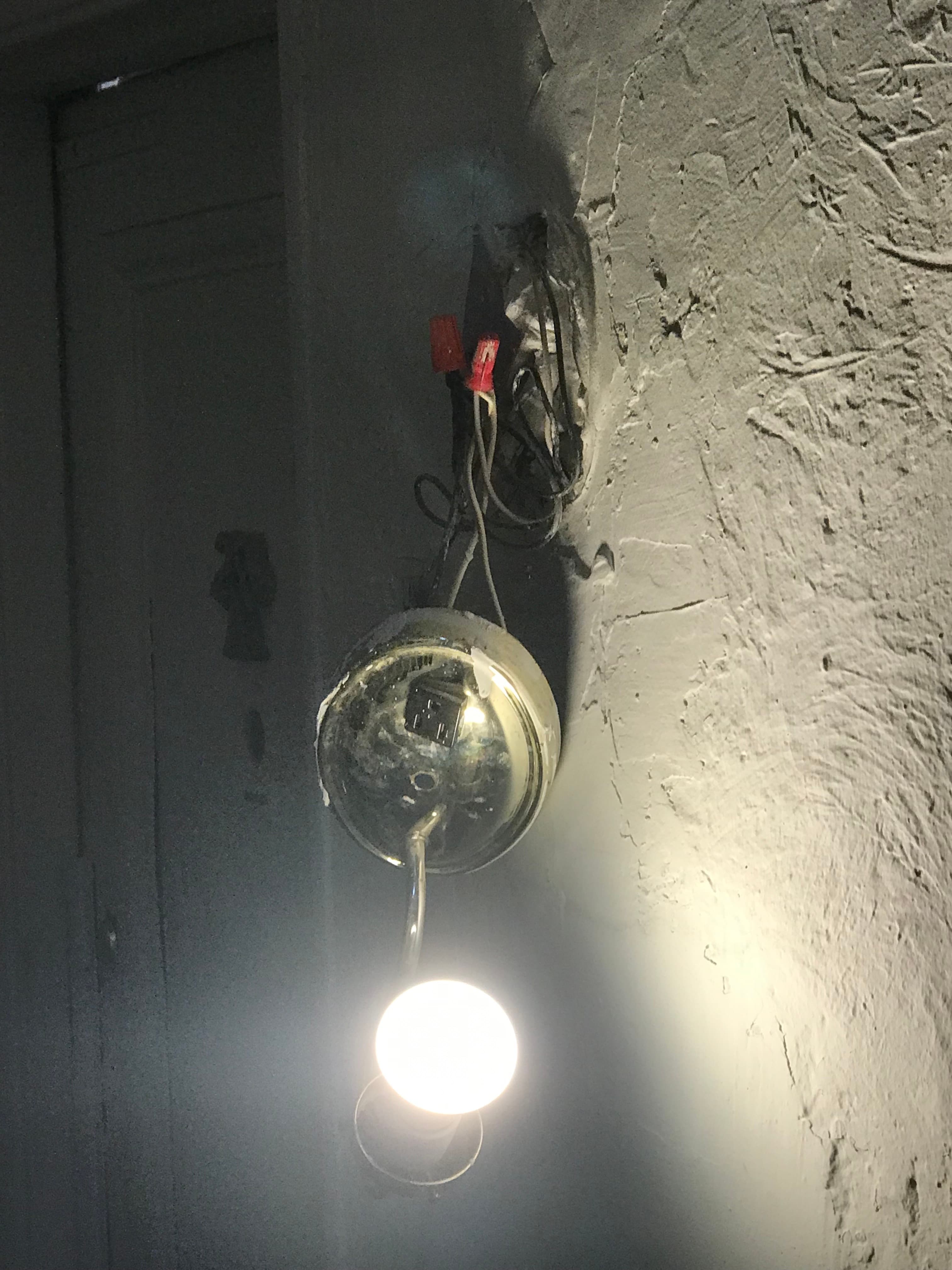 A broken hallway light fixture at 18 Gay Street hanging with exposed wiring, August 2021