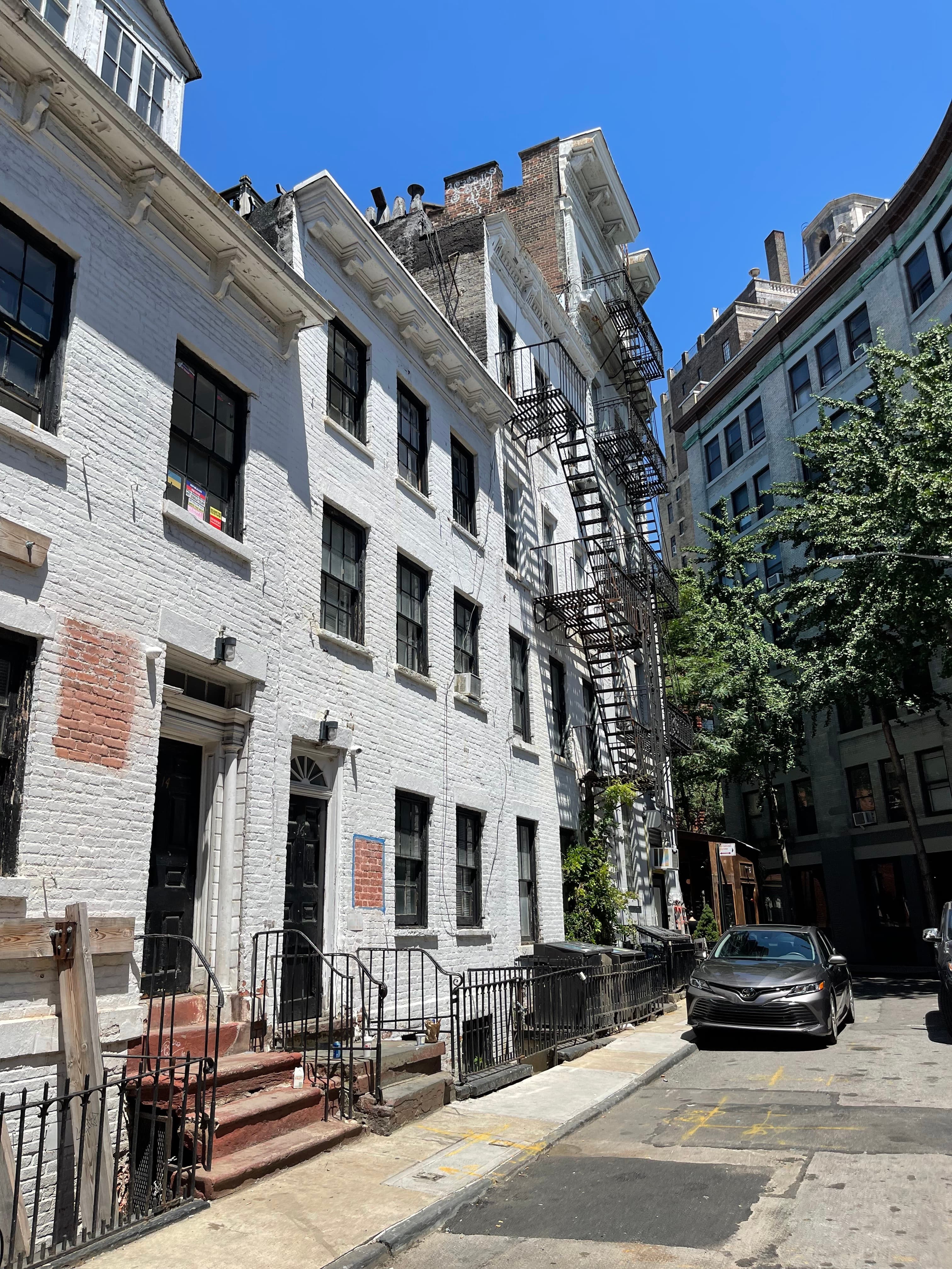 The white Federal-style houses at 14–18 Gay Street on July 10, 2022, a posted notice visible in a front window, shoring still in place