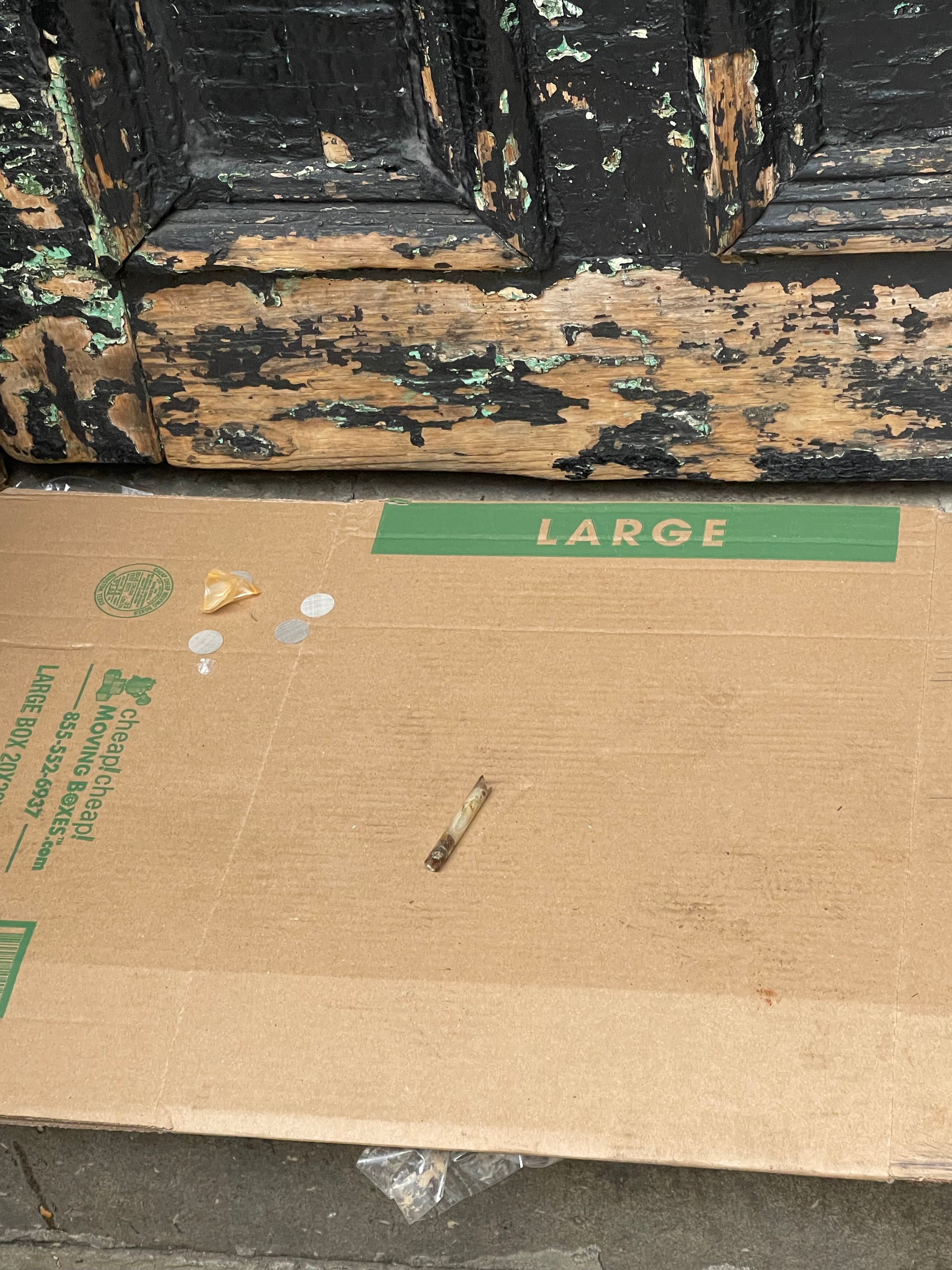 A syringe, a torn baggie and other drug debris left on flattened cardboard at the base of 18 Gay Street's peeling front wall, September 25, 2022