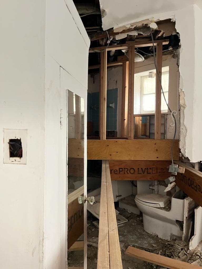 Structural lumber laid across the stripped ground floor at 18 Gay Street beside a fireplace mantel, February 2023