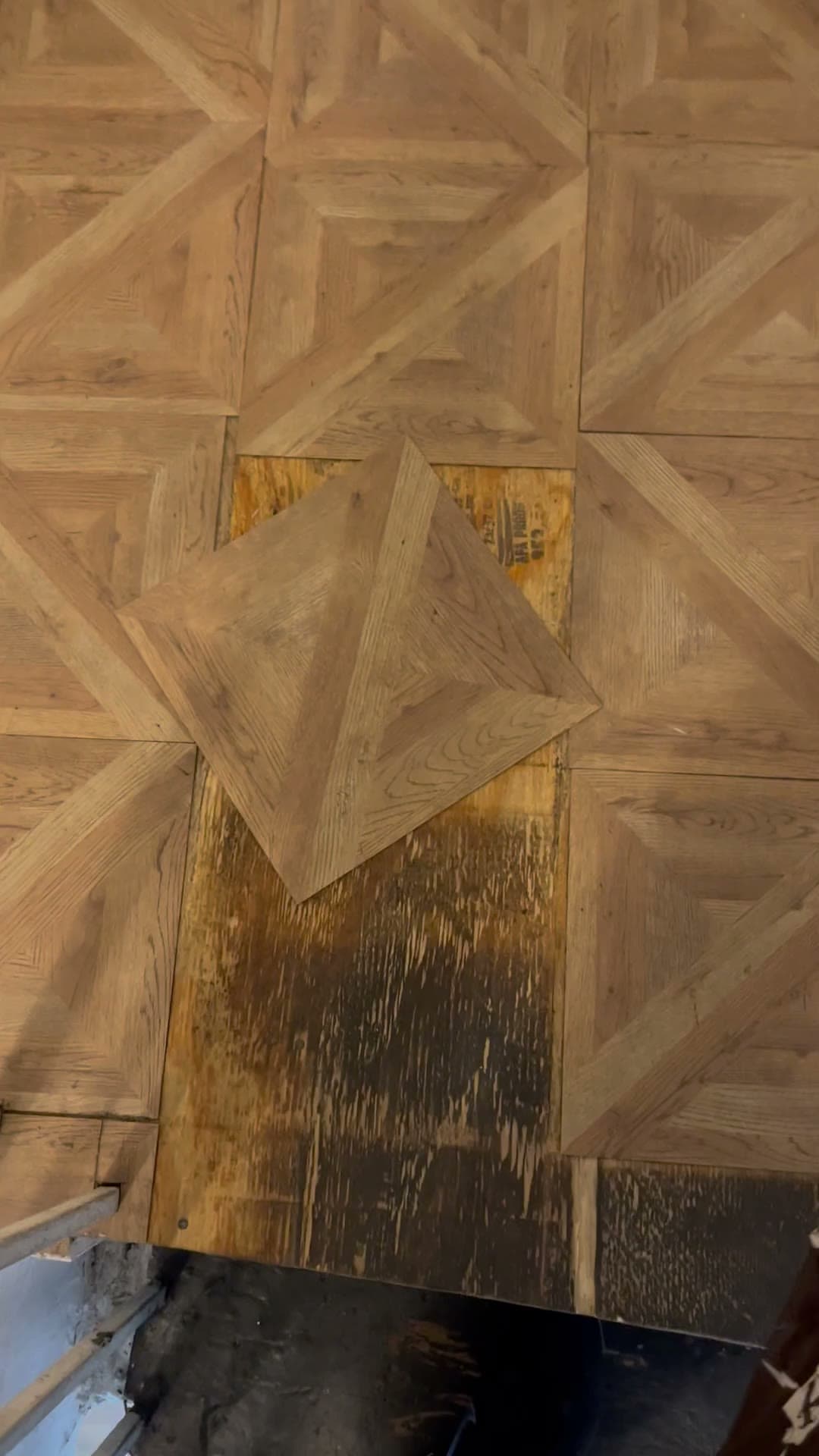 Loose floor tiles in a common area at 18 Gay Street, April 2023