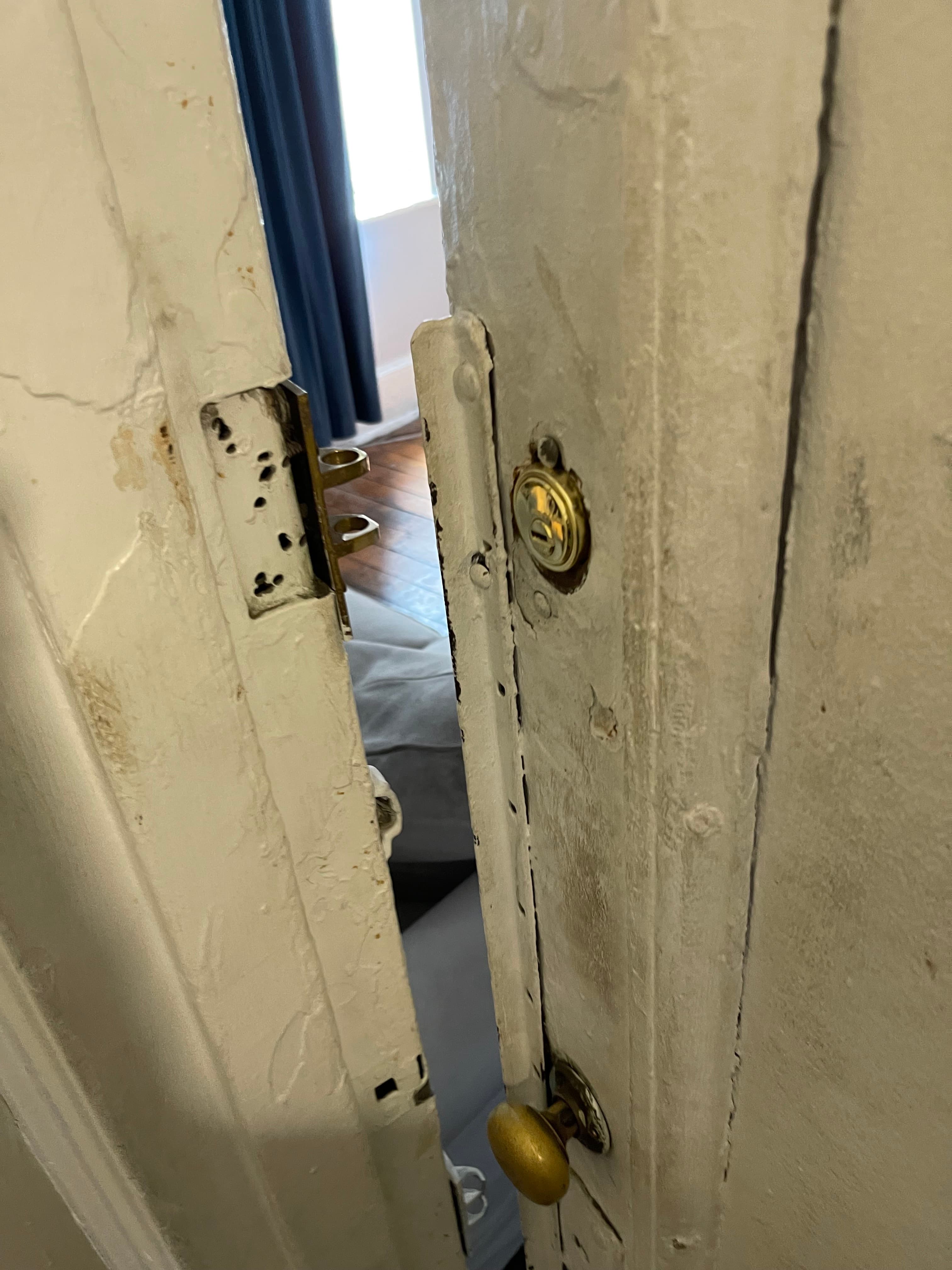 A door at 18 Gay Street left without a working lock — bare strike plate and empty screw holes, June 30, 2023