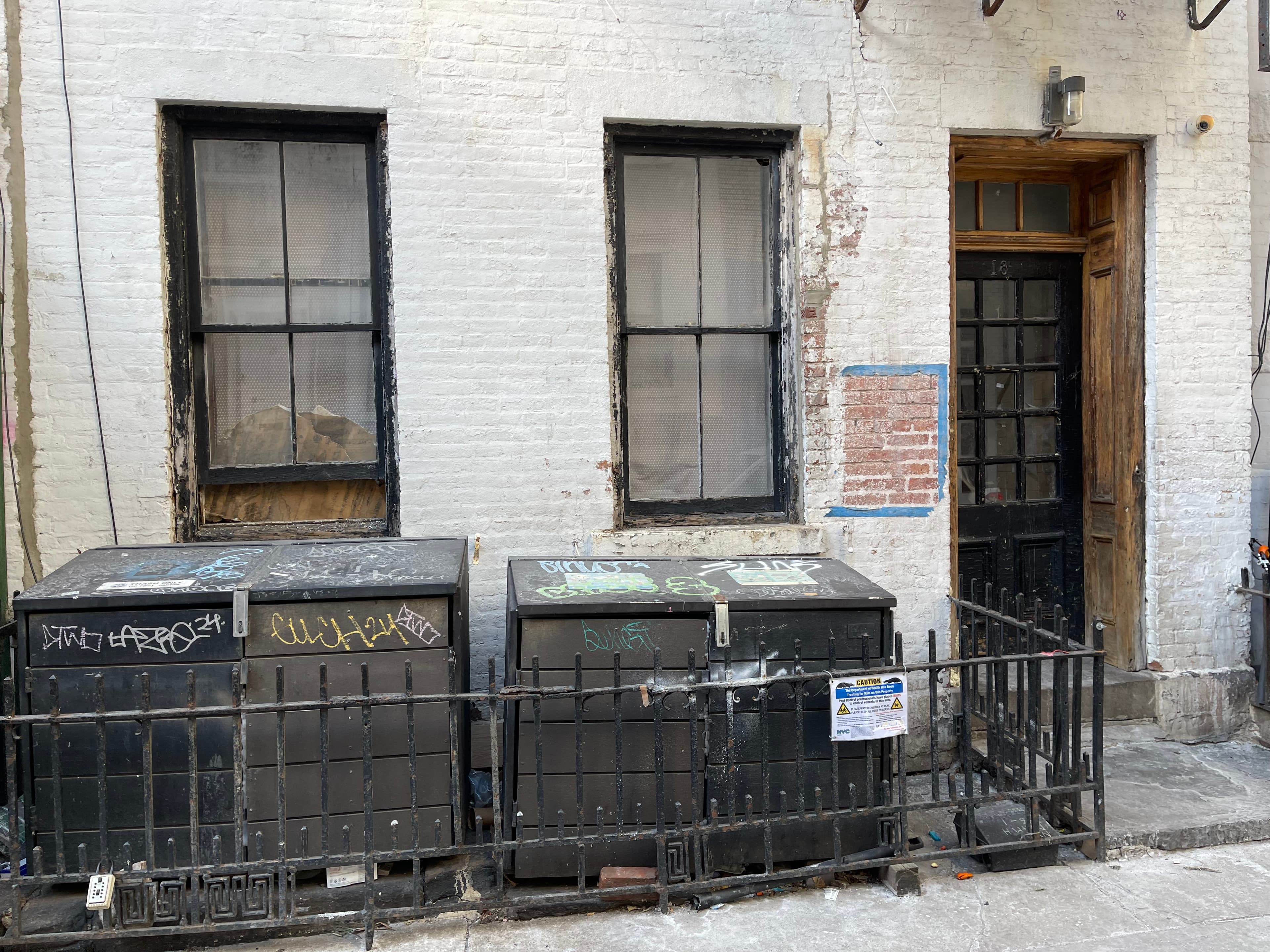 The street facade of 18 Gay Street in January 2024, with a front window left open during freezing weather and the ground-floor windows covered or broken
