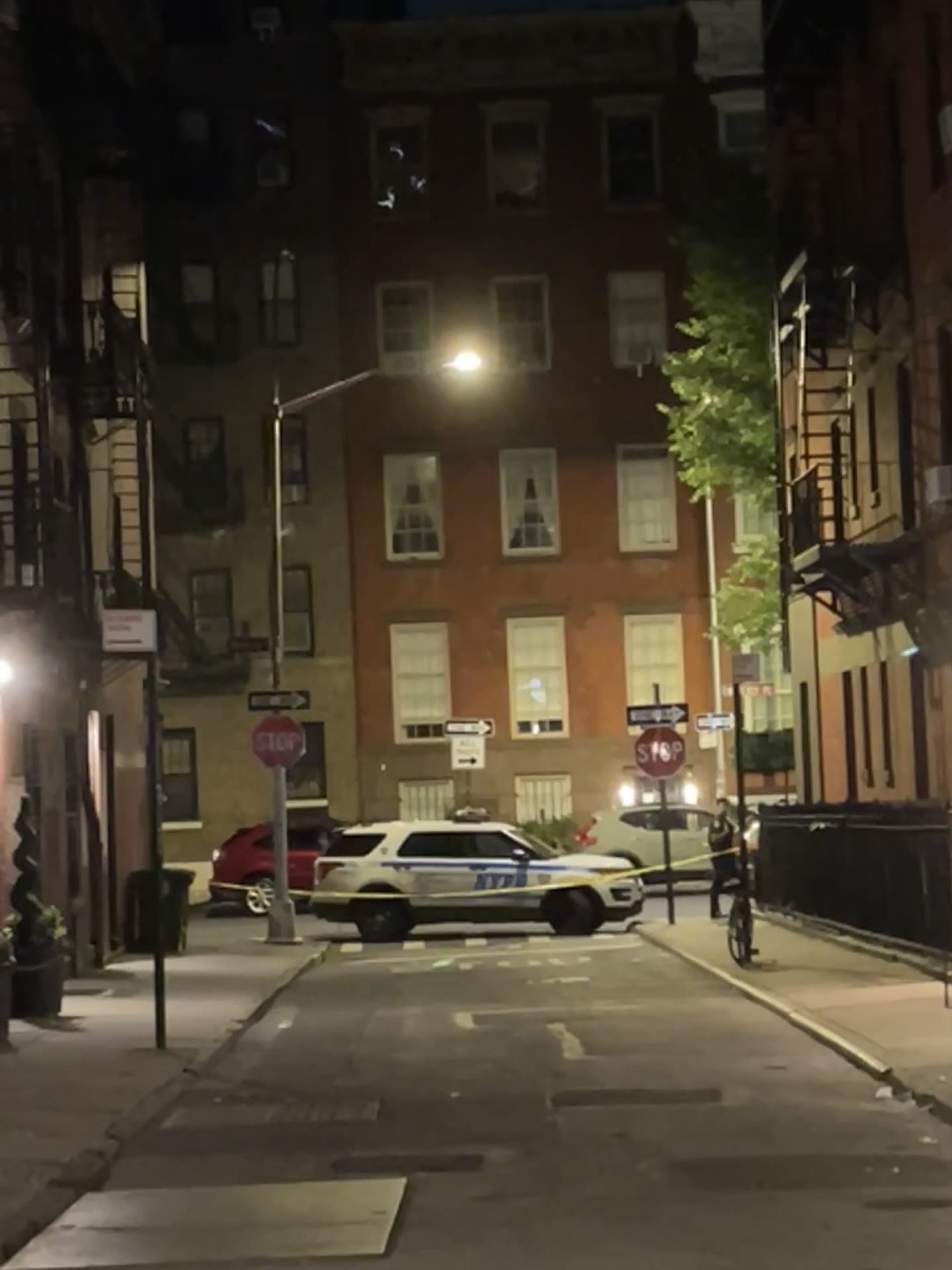 An NYPD patrol SUV parked across Gay Street at the corner of Christopher Street at night, after a stabbing in front of 18 Gay Street, June 2, 2024