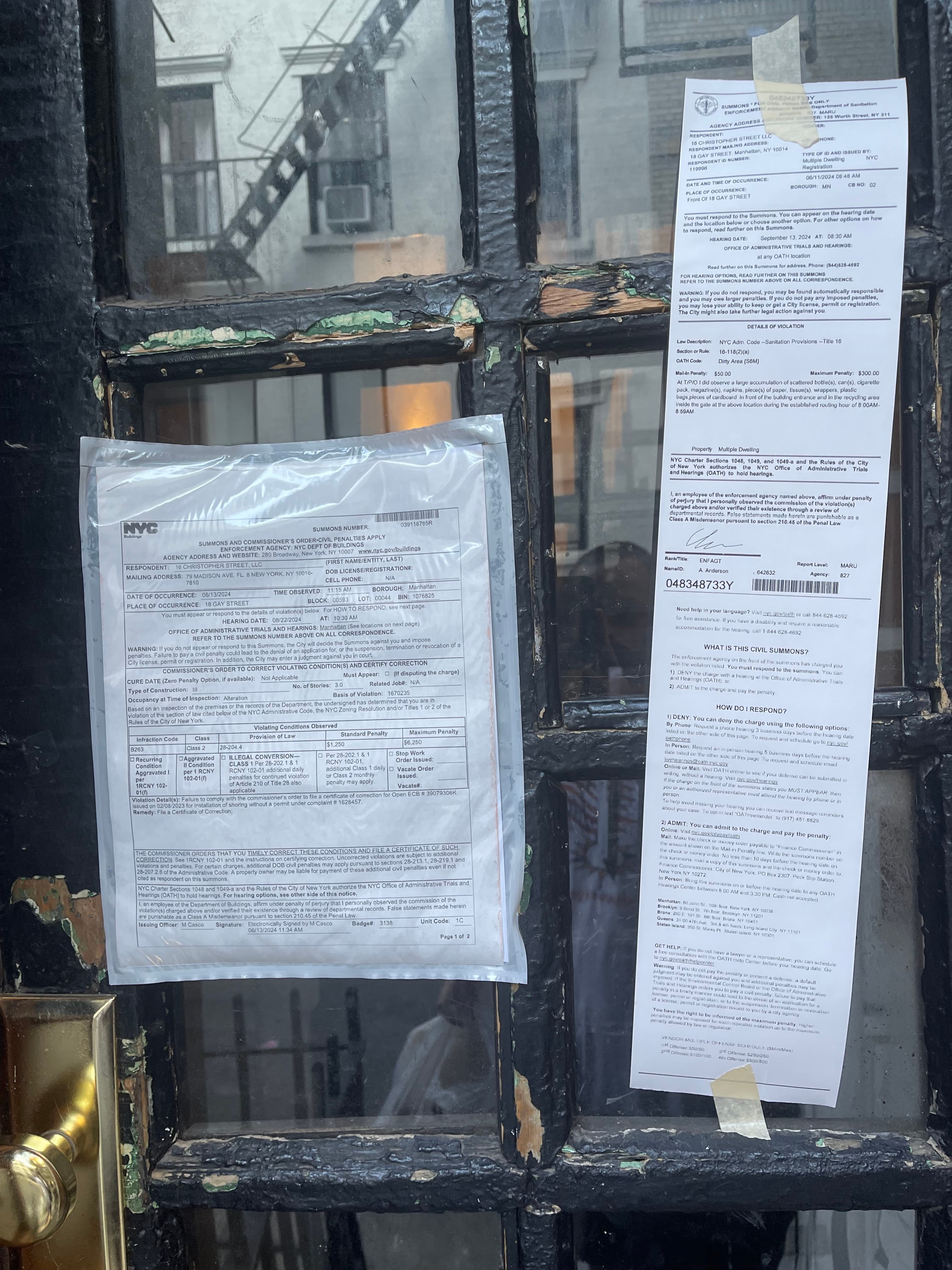 A Sanitation summons and a DOB violation notice taped to the front door of 18 Gay Street, photographed June 13, 2024