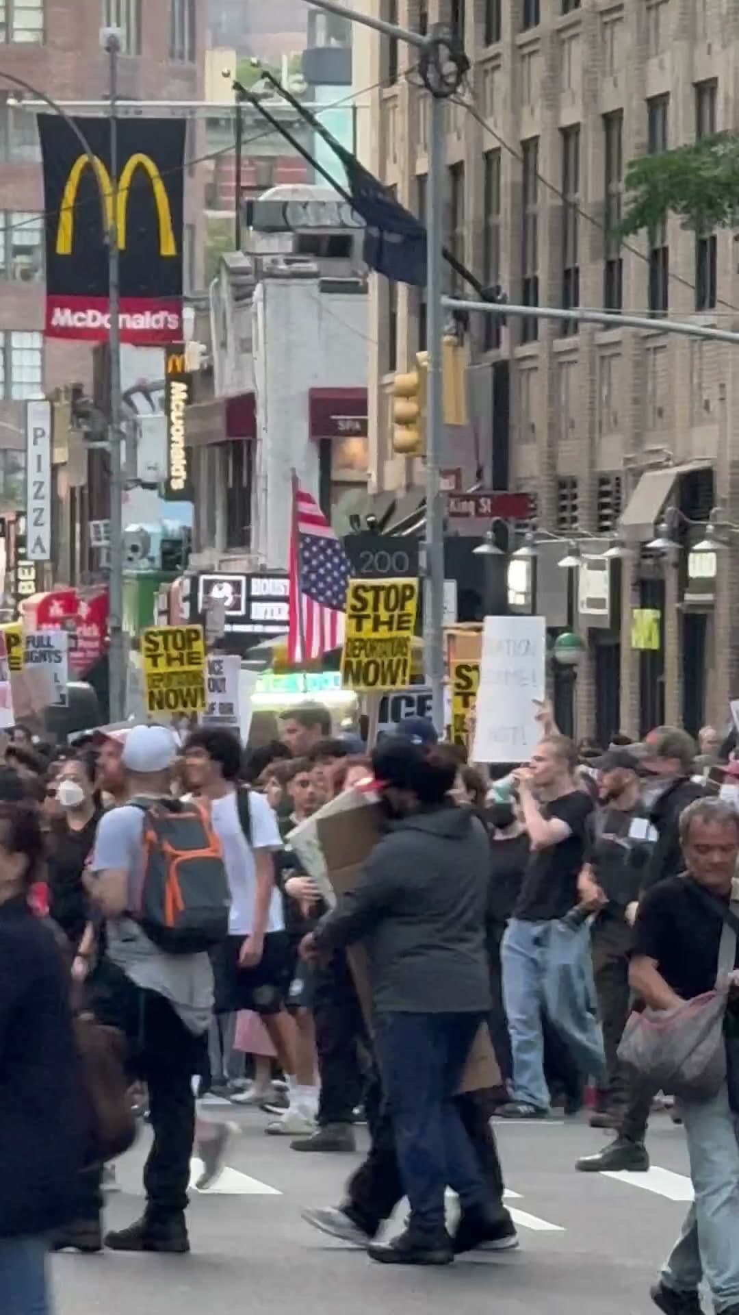 Anti-ICE demonstrators filling the street at Varick and Vandam with 'STOP THE DEPORTATIONS NOW!' and 'ICE OUT OF NYC' signs, June 10, 2025