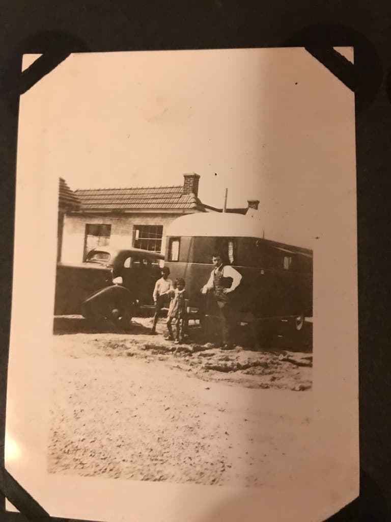Family members beside their trailer and car