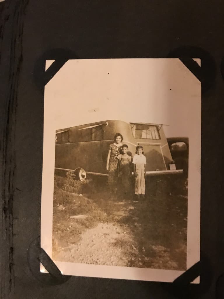 Three women of the family standing before their trailer