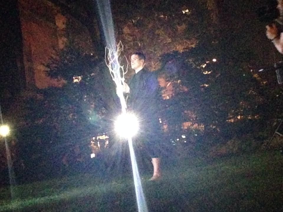 Russell Patrick Brown actuando de noche en el jardín bajo una luz brillante